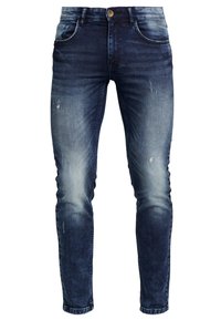 Vaqueros ajustados de color azul oscuro con áreas desgastadas y rasgadas, botón frontal y diseño de cinco bolsillos, mostrados sobre un fondo blanco.