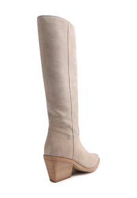 Botte beige en daim montant jusqu'au genou avec talon bloc en bois empilé et bout arrondi, vue de l'arrière sur fond blanc.