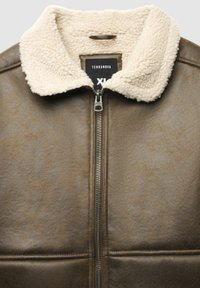 Brązowa kurtka z sztucznej skóry z beżowym kołnierzem z owczej wełny, zamkiem błyskawicznym i pikowanym detalem z przodu. Oznaczona "Terranova", rozmiar XL.