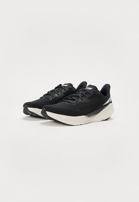 Black running shoes with a textured upper, contrasting white sole, and subtle silver accents. Features traditional lacing and cushioned design.