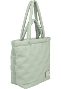 Quilted tote bag i dæmpet mintgrøn farve, med to lange stropper, rektangulær form og et syet mærkelabel på siden.