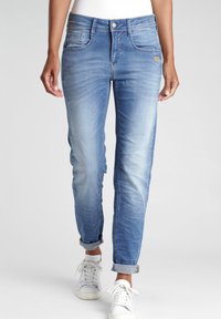 Helles blauer Denim-Jeans mit schlanker Passform, fünf Taschen und aufgerollten Säumen. Verfügt über leichte Ausbleichung und ein dezentes Logo an der Vorderseite.