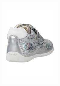 Silver children's shoe with a textured, iridescent upper, secure strap closure, and a white rubber sole. Features GeoX branding on heel.
