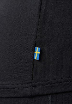 Black fabric sportswear featuring a small Swedish flag tag. Smooth texture with visible stitching details, highlighting its fitted design.