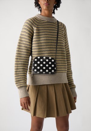 Striped knit sweater in beige and yellow, with a grey ribbed collar; pleated brown skirt; small black polka dot crossbody bag.