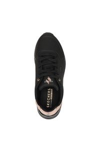 Baskets Skechers noires avec une tige texturée, un design à lacets et des accents dorés roses sur le talon. Comprend des perforations et des détails de logo.
