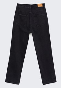 Jeans de mezclilla negra con un diseño de pierna recta, cinco bolsillos y un parche de cuero en la cintura. La tela tiene una textura suave.