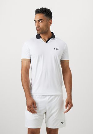 Weißes Poloshirt mit schwarzem Kragen und braunen Akzenten, kurze Ärmel und ein kleines "BOSS"-Logo auf der Brust. Getragen mit weißen Shorts.