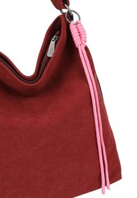 Rode suède handtas met een zachte textuur, ritsopening aan de bovenkant en roze gevlochten accentdetails. Voorzien van een zilverkleurig hardwarelabel.