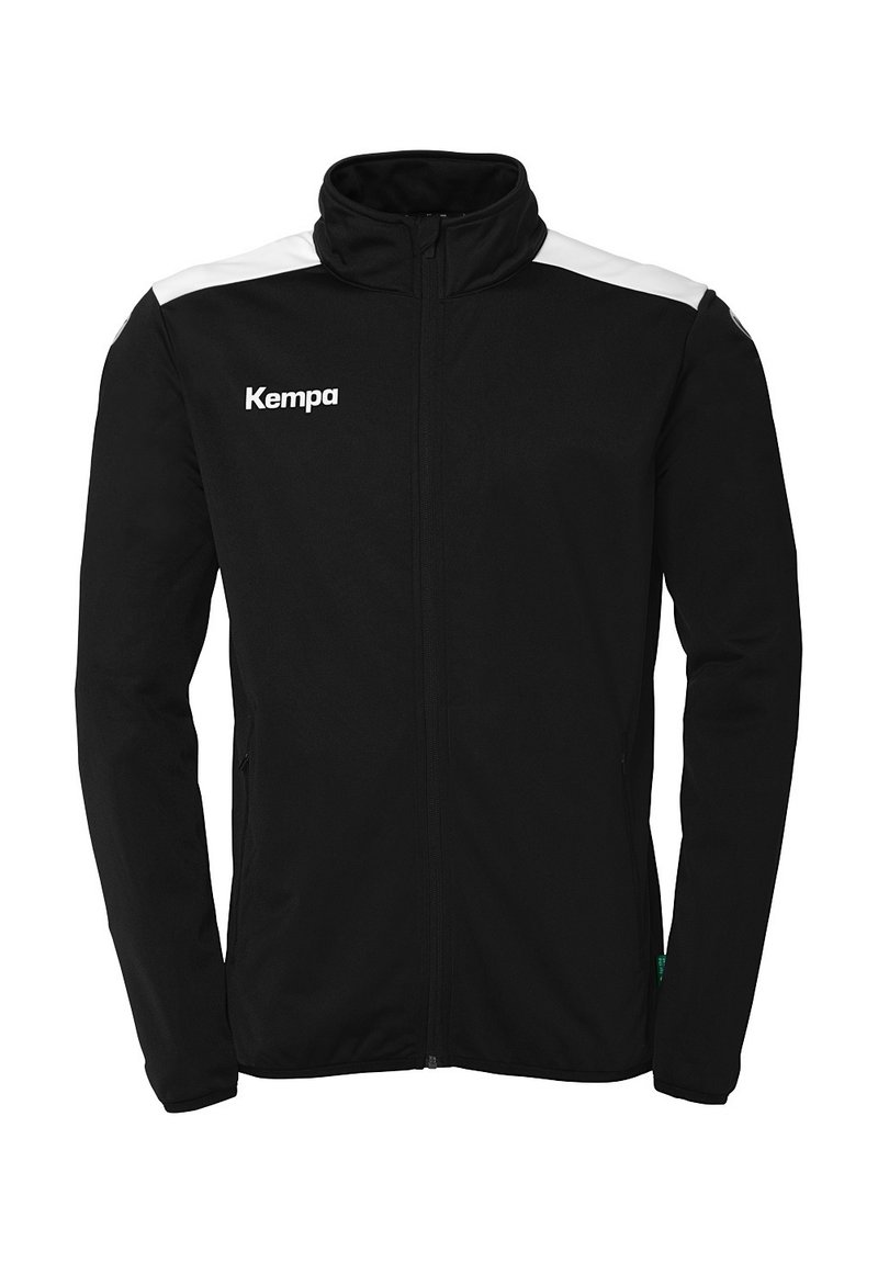 Zwarte sportjack met volledige ritssluiting, hoge kraag, witte schouderaccenten en een "Kempa" logo aan de linkerkant.