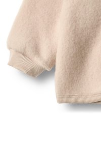 Světle béžový vlněný svetr s rukávem s žebrovaným lemem a spodním okrajem, předvádějící měkkou, texturovanou tkaninu na bílém pozadí.