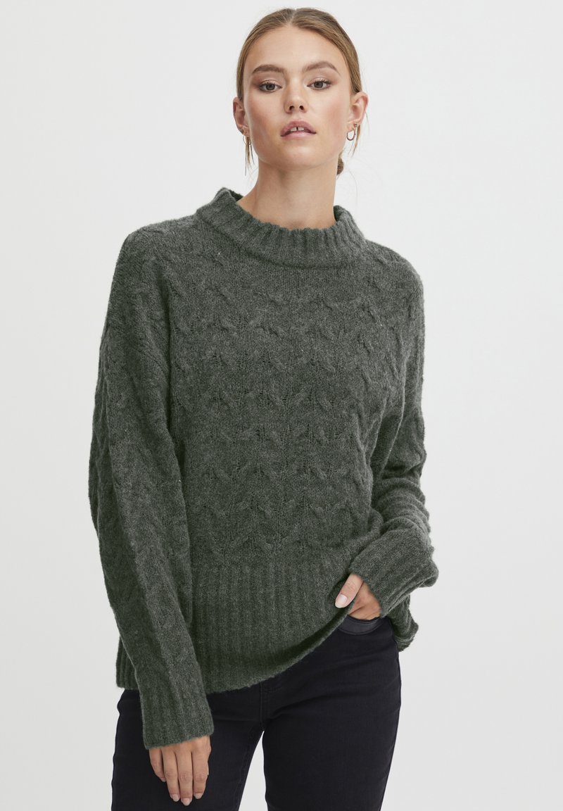Dunkelgrüner Strickpullover mit hohem, geripptem Kragen und strukturiertem Muster. Verfügt über lange Ärmel und einen gerippten Saum für zusätzlichen Details.