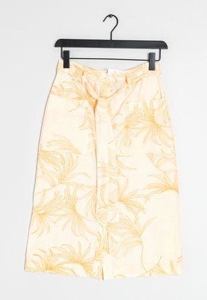Jupe midi florale présentant un fond jaune clair avec des motifs de feuilles dorées contrastants, fabriquée en tissu doux, avec une poche avant.