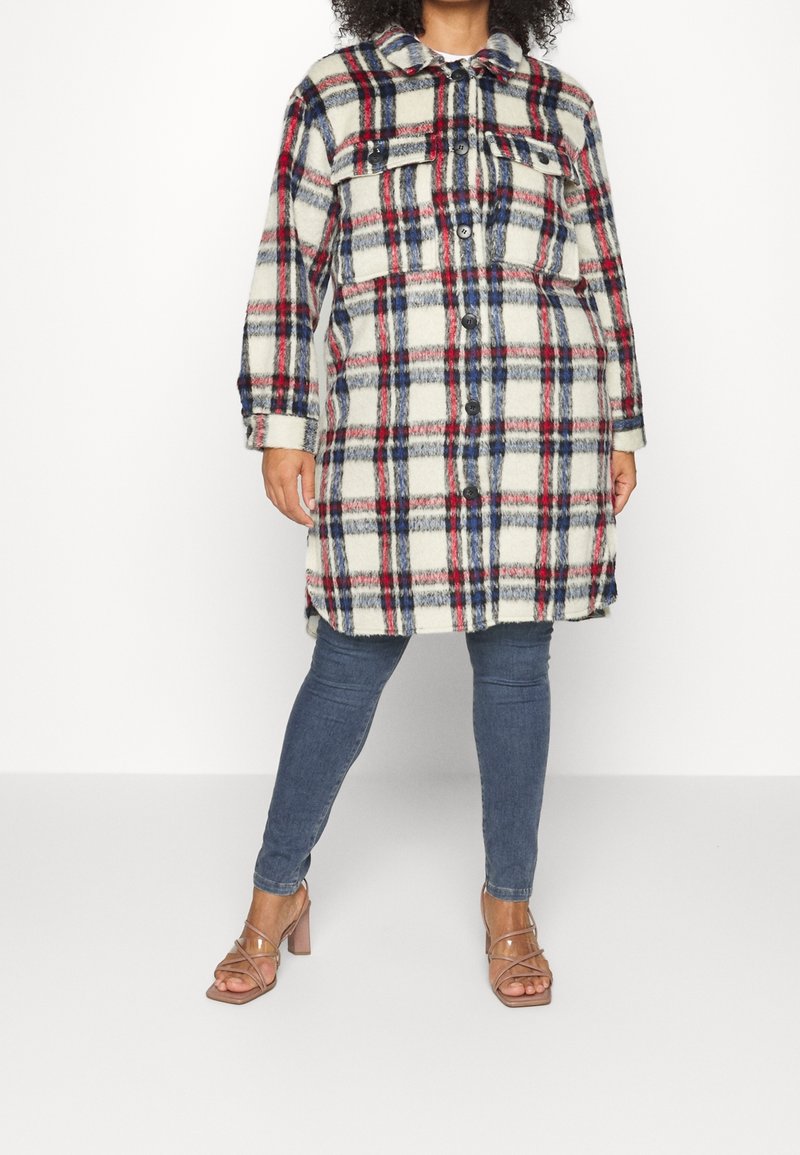 Ruutukuvioinen, pitkähihaisella takilla, jossa on beige, punainen ja sininen sävy, kaksi rintataskua ja napp closure, yhdistettynä slim jeans -farkkuihin ja korkokenkiin.