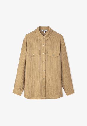 Chemise beige à boutons avec un tissu texturé et côtelé. Elle possède un col, deux poches poitrine et des manches longues. Design ajusté classique.