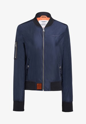 Veste bombardier marine avec fermeture éclair à l'avant, poignets et ourlet côtelés. Elle possède des poches latérales, une doublure orange et un patch près du bas.