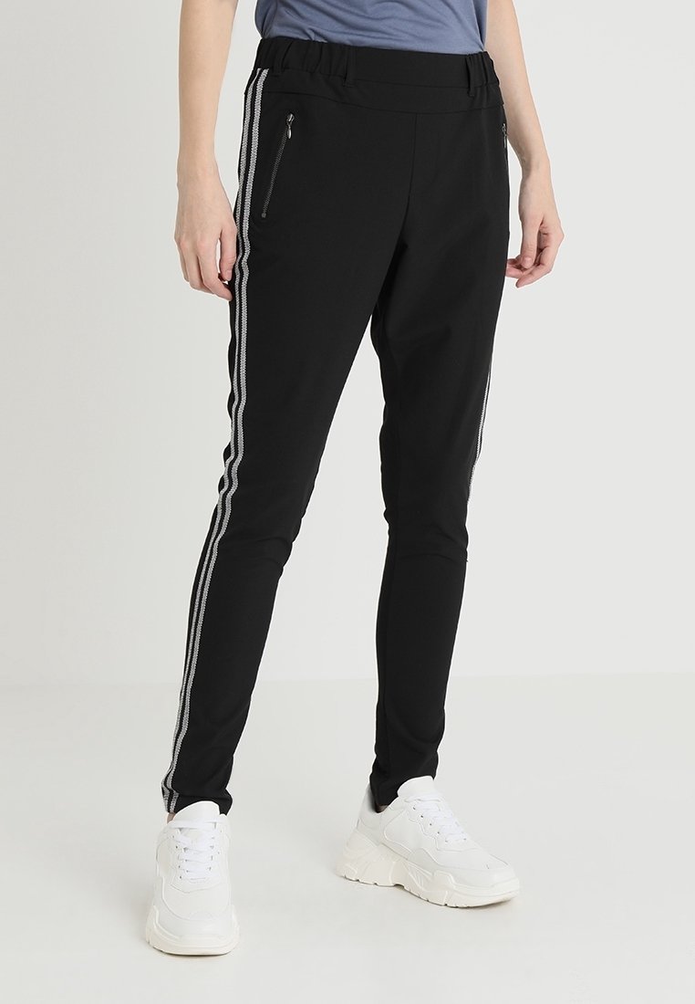 Zwarte sportieve broek met een elastische tailleband, zijritsen en witte strepen langs de zijkanten, gemaakt van een glad, flexibel materiaal.
