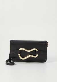 Schwarze Leder-Clutch mit wellenförmigem goldfarbenem Schnallendetail und abnehmbarem Handgelenkriemen vor weißem Hintergrund.