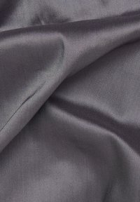 Grijze satijnen stoftextuur met een gladde afwerking, met een subtiele glans en een diagonale weefpatroon. Vouwen creëren zachte, vloeiende draperingen.