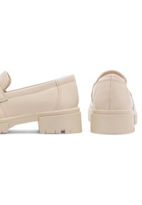 Béžové kožené poltopánky na sklzu s plochou gumovou podrážkou, zaoblenou špičkou a jemným podpätkom, so viditeľným šitím a hladkým povrchom.