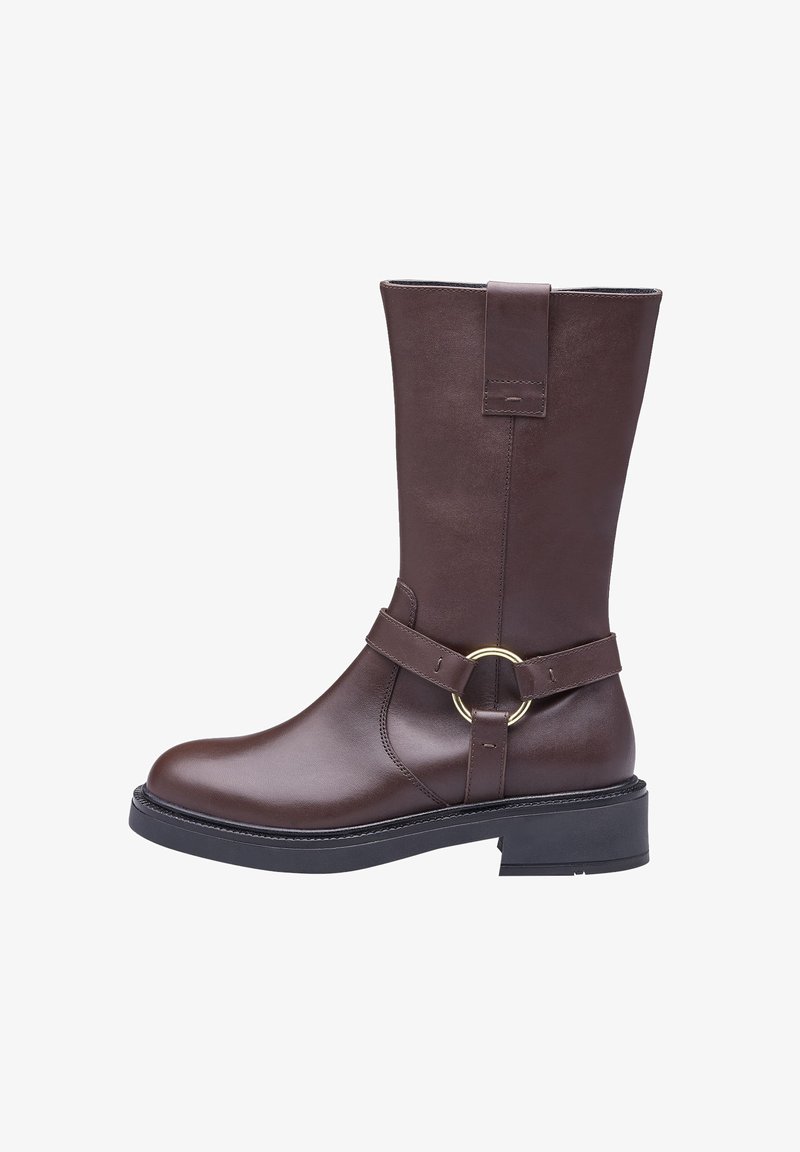 Braune Leder kniehohe Stiefel mit einem runden goldenen Akzent, flacher Sohle und vertikalen Nahtdetails. Verfügt über einen breiten Riemen am Knöchel.