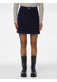 Mörkblå manchester mini kjol med midjeband, knappstängning och två framfickor. Matchad med svarta knähöga stövlar.