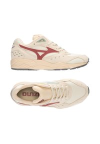 Sneakers atletiche beige con accenti rossi, tomaia in rete e pelle, colletto imbottito, lacci, suola in gomma e dettagli verdi sui lati.