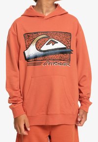 Sudadera de color óxido, hecha de material suave, con un bolsillo frontal y un diseño gráfico con un motivo de montaña y el texto "Quiksilver".