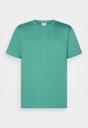 T-shirt bleu sarcelle à manches courtes avec col rond et petit logo Champion sur la poitrine et la manche, présenté sur un fond uni.