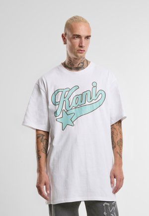 Balta medvilninė oversized marškinėlių palaidinė su turkio spalvos "Kani" logotipu ir žvaigždės grafika priekyje. Trumpomis rankovėmis, laisvas kirpimas.