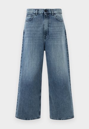 Jeans de mezclilla de tiro alto y pernera ancha en azul claro, con bolsillos frontales y costuras clásicas. Sin adornos visibles.