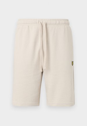 Beiga bomullsshorts med elastisk midja och dragsko. Har en liten svart logotyp på vänster lår. Slät textur, knälång.