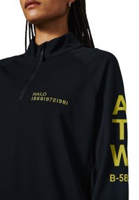 Schwarzer Quarter-Zip-Sweatshirt aus strukturiertem Stoff. Mit gelbem Text "HALO 196819721981" auf der Brust und "ATW B-58" am Ärmel.