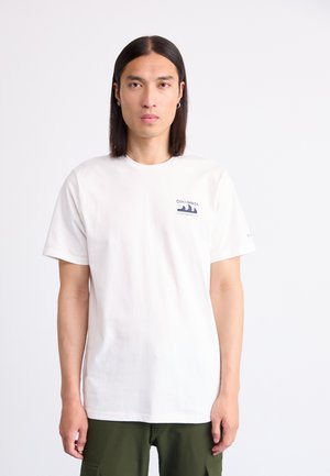 White cotton t-shirt with short sleeves; features a blue Columbia logo on the left chest. Worn with green cargo pants.