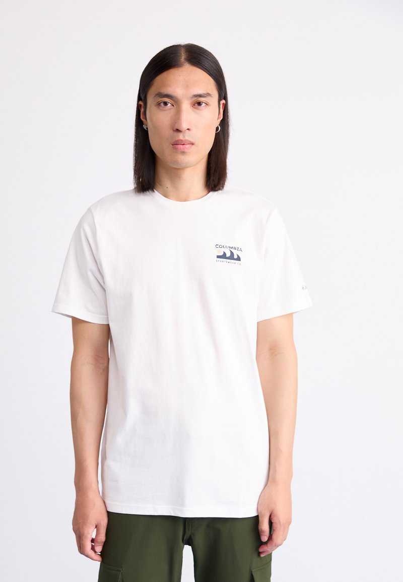 White cotton t-shirt with short sleeves; features a blue Columbia logo on the left chest. Worn with green cargo pants.