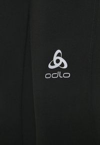 Ropa de entrenamiento negra con una tela suave y texturizada que presenta el logo de Odlo en blanco. El diseño es ajustado al cuerpo con costuras planas para mayor comodidad.