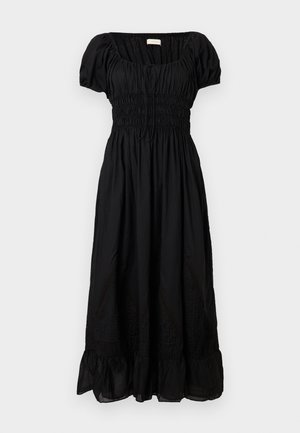 Svart midiklänning med puffärmar, rynkad överdel, insvängd midja och volangkant mot en enfärgad vit bakgrund.