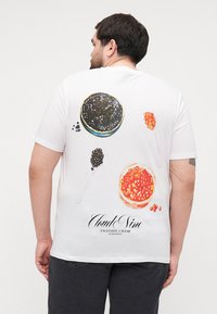 White t-shirt featuring colorful caviar illustrations on the back, with the text "Cloud Nine Exclusive Caviar" at the bottom.