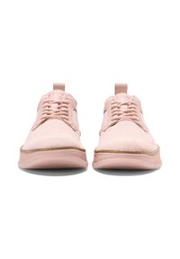 Light pink sneakers with a textured knit upper, lace-up design, and a rubber sole featuring a subtle brown accent along the edge.