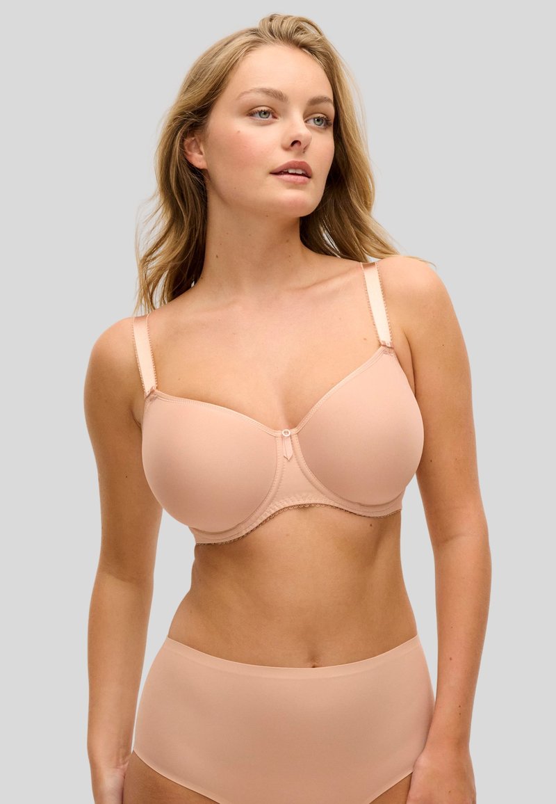 Vaaleanpunainen muotoiltu rintaliivit, joissa sileä kangas, toppituki, säädettävät olkaimet ja koristeellinen pitsikoriste kuppien alla.