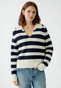 Navy-blaues und cremefarbenes gestreiftes Sweatshirt mit V-Ausschnitt und Kragen, aus einem weichen Strickmaterial. Rippenbündchen und Saum, lockere Passform.