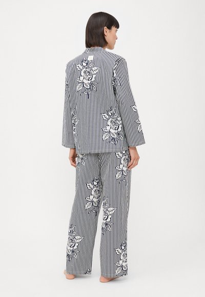 Striped pajama set in navy and white with floral patterns; long-sleeved top and wide-leg pants; cotton material; relaxed fit.