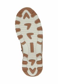 Semelle d'une chaussure avec une base crème et des motifs de traction marron, présentant un design angulaire, un logo central et des sections texturées.