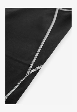 Sort stof med en glat tekstur, der har kontrasterende grå syninger langs sømme og en foldet kant for detaljering.