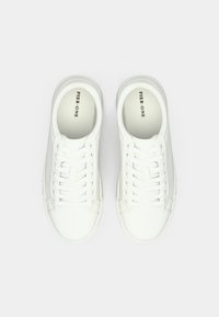 Valged tossud, mis on valmistatud siledast nahast, ümmarguse varbaga, paelaga kinni seotud disainiga ja minimaliseeritud brändinguga tallas. Peened tekstuursed detailid.