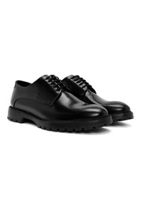 Scarpe in pelle nera con superficie liscia, punta arrotondata e suola in gomma resistente. Presentano un design tradizionale con lacci e occhielli.