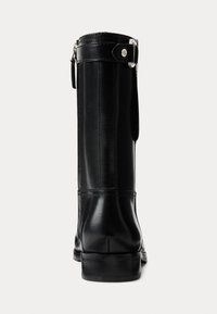 Black leather knee-high boot featuring a smooth finish, sturdy sole, and a side buckle detail. Clean lines with a sleek silhouette.