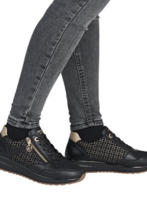 Baskets noires et dorées avec une tige en textile à motifs, des accents en cuir, des fermetures à lacets et à zip, et des semelles en caoutchouc.