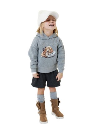 Sweat à capuche gris avec un motif de chien, short noir à pois, chaussettes grises et bottes marron avec un nœud et semelles blanches. Textures douces partout.