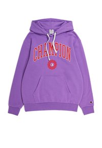 Sudadera morada con un bolsillo frontal, texto "CHAMPION" en rojo y parche del logo. Cuenta con cordones y puños acanalados. Material suave de algodón.